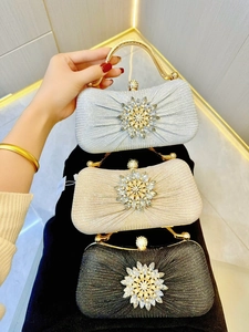 Detail of sparkling sequin evening clutches with crystal floral pattern and metal handles