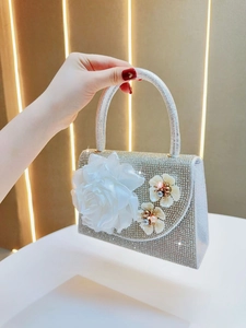 Detail of silver rhinestone evening bag featuring large mesh flower and pearl centers