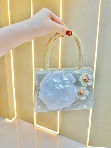 Macro detail of silver rhinestone evening bag with a satin flower and pearl accents
