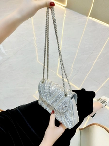 Detailed view of silver evening clutch bag with sparkling rhinestones and pearls decoration