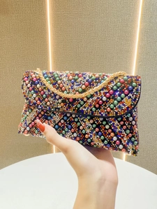 Close-up of a colorful beaded evening clutch bag with sequins and a gold chain strap