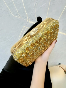 Détails d'une pochette de soirée dorée ornée de cristaux ambrés et de strass étincelants