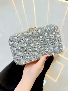 Détail de la pochette de soirée argentée avec strass denses et grands cristaux