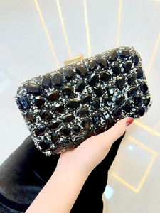Détail d'une pochette de soirée noire avec strass scintillants et fermoir doré chic