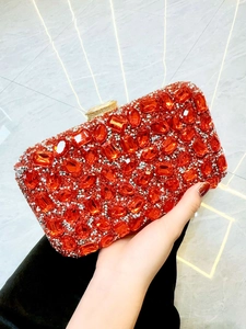 Gros plan d'une pochette de soirée rouge sertie de strass avec un cadre doré chic