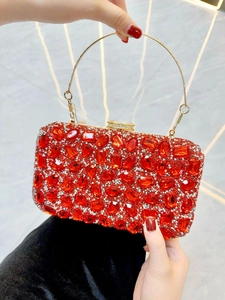 Détail de pochette de soirée rouge sertie de strass avec poignée en anneau doré