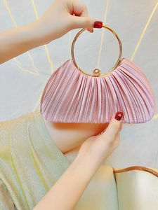 Détail d'une pochette de soirée en satin plissé rose avec poignée en métal doré