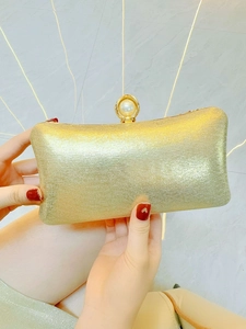 Elegant gold evening clutch bag with silk texture and large pearl clasp for formal events