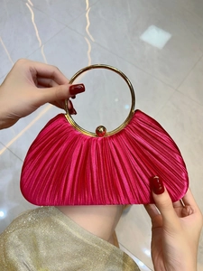 Détail de la pochette de soirée en satin plissé fuchsia avec large poignée ronde dorée