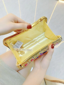 Macro view of crystal evening bag interior with yellow satin lining and gold chain strap