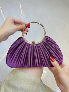 Détail de la pochette de soirée plissée violette avec élégante poignée dorée ronde