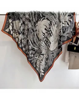 Detail of tropical palm leaf print on large square silk scarf with brown hemmed edges