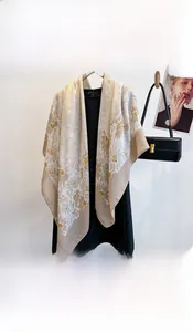 Detail of elegant beige square scarf with vintage floral patterns on a wooden hanger