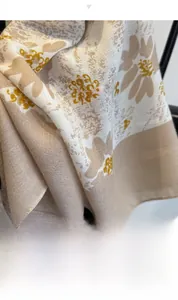 Detail of floral linen texture scarf draped on a minimalist black metal display rack