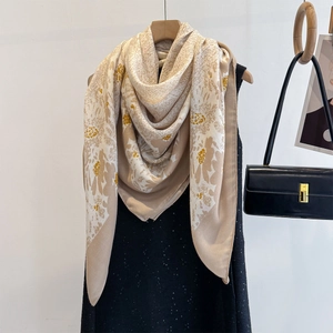 Chic linen-feel square scarf with yellow floral patterns draped over a black sequin dress