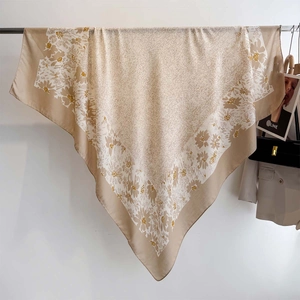 Detailed close-up of a floral print cotton linen square scarf with gold and beige patterns