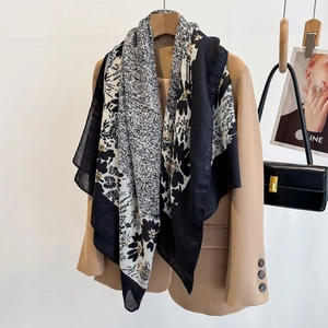 Detail of floral print scarf draped over a blazer with elegant black and white pattern