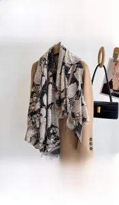 Detail of vintage leaf print silk scarf styled elegantly on a camel wool blazer jacket