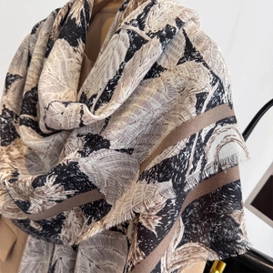 Detail of vintage leaf pattern silk scarf with frayed edges and soft draped texture