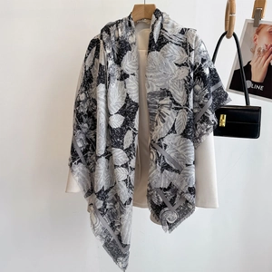 Black and white leaf print silk scarf with fringe, draped over a white blazer