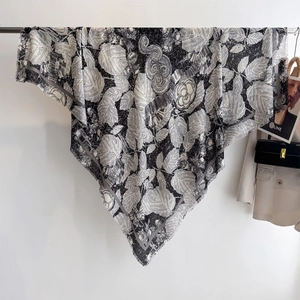 Detail of a large square floral shawl with intricate black and white patterns and fringe edges