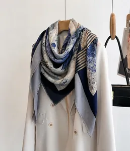 Detail eines Farblock-Schals mit Marmordruck und Streifen auf einem weißen Blazer