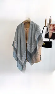 Detail of blue striped scarf with houndstooth and polka dots on a camel blazer