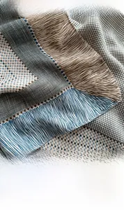 Close-up of multicolored geometric striped silk scarf showing fine fabric texture and stitching
