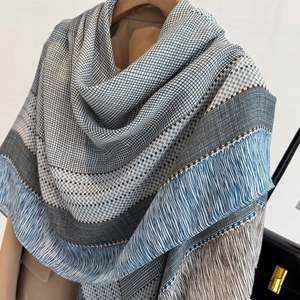 Detail view of woven striped scarf showing blue fabric texture and fringe edges