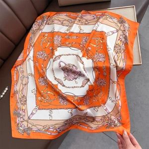 Orange silk-feel square scarf featuring classic chain, belt, and vintage bag prints
