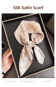 Gros plan du foulard carré en satin de soie champagne avec motifs paisley blancs