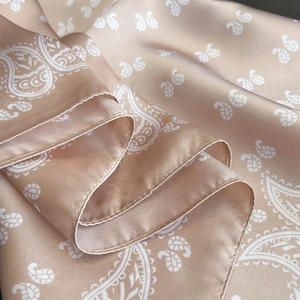 Détail de l'écharpe en soie paisley champagne montrant les plis doux et les bords ourlés