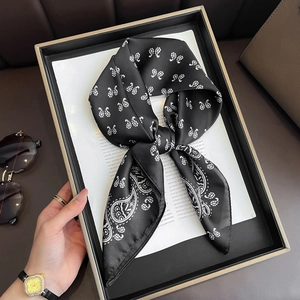 Foulard en soie noir de 70cm à motif paisley élégamment noué sur un plateau