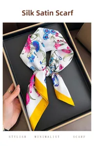 Close-up of silk-like satin square scarf with floral prints and mustard yellow border