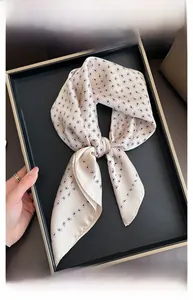 Dettaglio della trama di un foulard in raso di seta champagne con motivo paisley