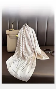 Dettaglio della trama del foulard in seta con motivo paisley su una borsa classica