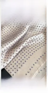 Dettaglio ravvicinato delle cuciture precise e del bordo rifinito su un foulard di seta