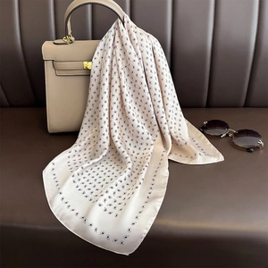 Foulard di raso champagne con stampa paisley drappeggiato su una borsa di pelle