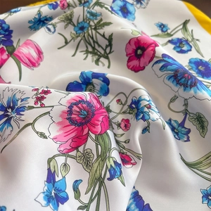 Detail of floral print silk scarf featuring pink poppies and blue cornflowers on white