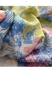 Dettaglio macro di un foulard in seta con motivi tropicali colorati di fiori e alberi