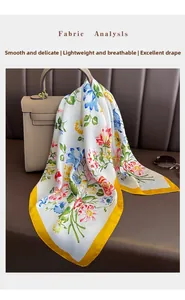 Detail of floral printed silk scarf showing soft fabric texture draped on a leather bag
