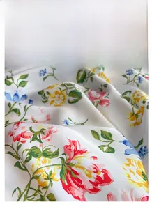 Detail shot of the silky satin square scarf featuring vibrant colorful floral prints