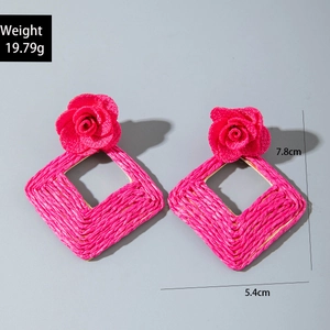 Detail view of pink raffia flower earrings showing 7.8cm height and 5.4cm width size