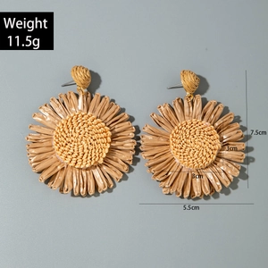 Detail view of handmade raffia sunflower earrings with precise size and weight markings