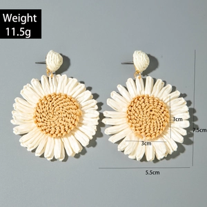 Detail view of woven raffia daisy earrings with dimensions 7.5cm by 5.5cm and weight info