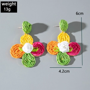 Detailed view of handmade raffia flower earrings with colorful woven petals and white rose