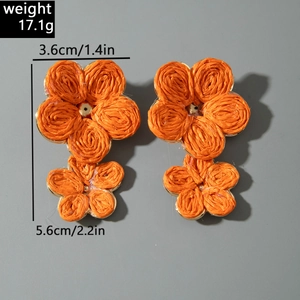 Detail view of orange woven flower earrings with 5.6cm length and 3.6cm width dimensions