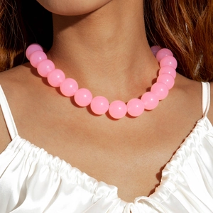 Close-up of pink oversized frosted acrylic beads on a fashion necklace worn by a model
