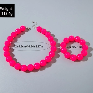 Detail of neon pink beaded necklace and bracelet set with silver clasp on grey background