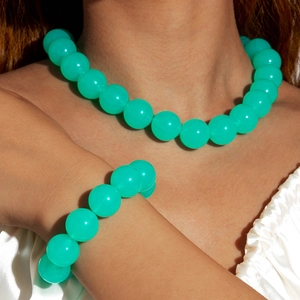 Detail of translucent turquoise acrylic beaded necklace and bracelet set on model